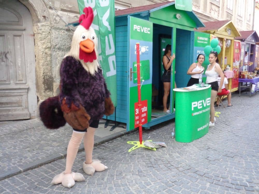 Green and blue stall with a mascot at Špancirfest in Varaždin
