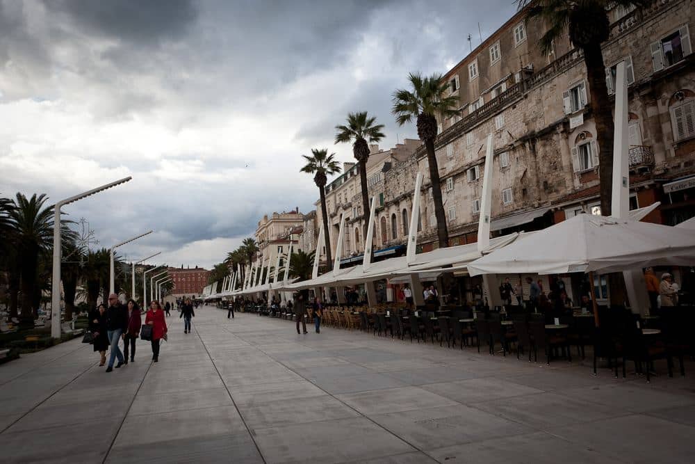 Die Riva in Split an einem bewölkten Dezembertag mit Spaziergängern in Wintermänteln