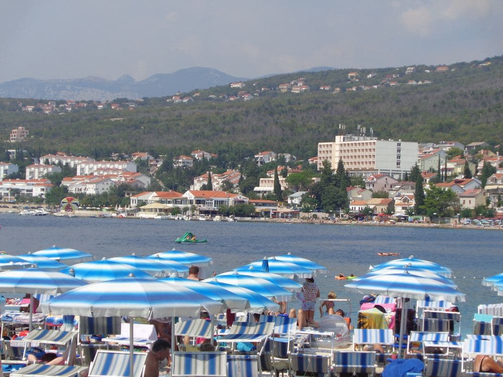 Sunbeds and parasols on the beach at Selce: the paid strip is usually a few metres from a free one