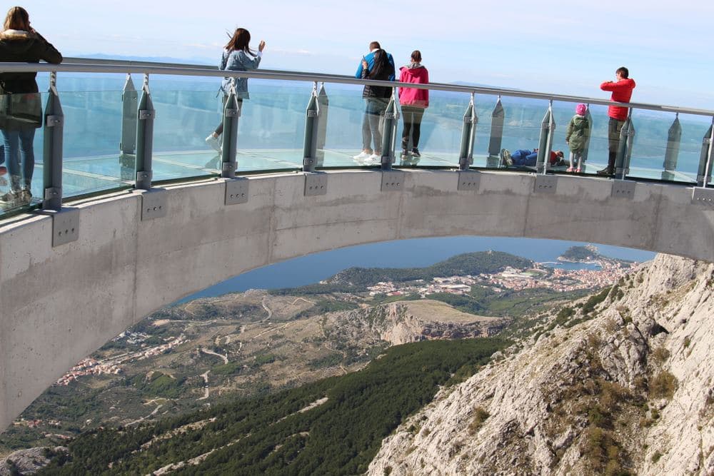 Blick durch den Glasboden des Skywalk auf die Halbinsel Sveti Petar und Makarska weit unten