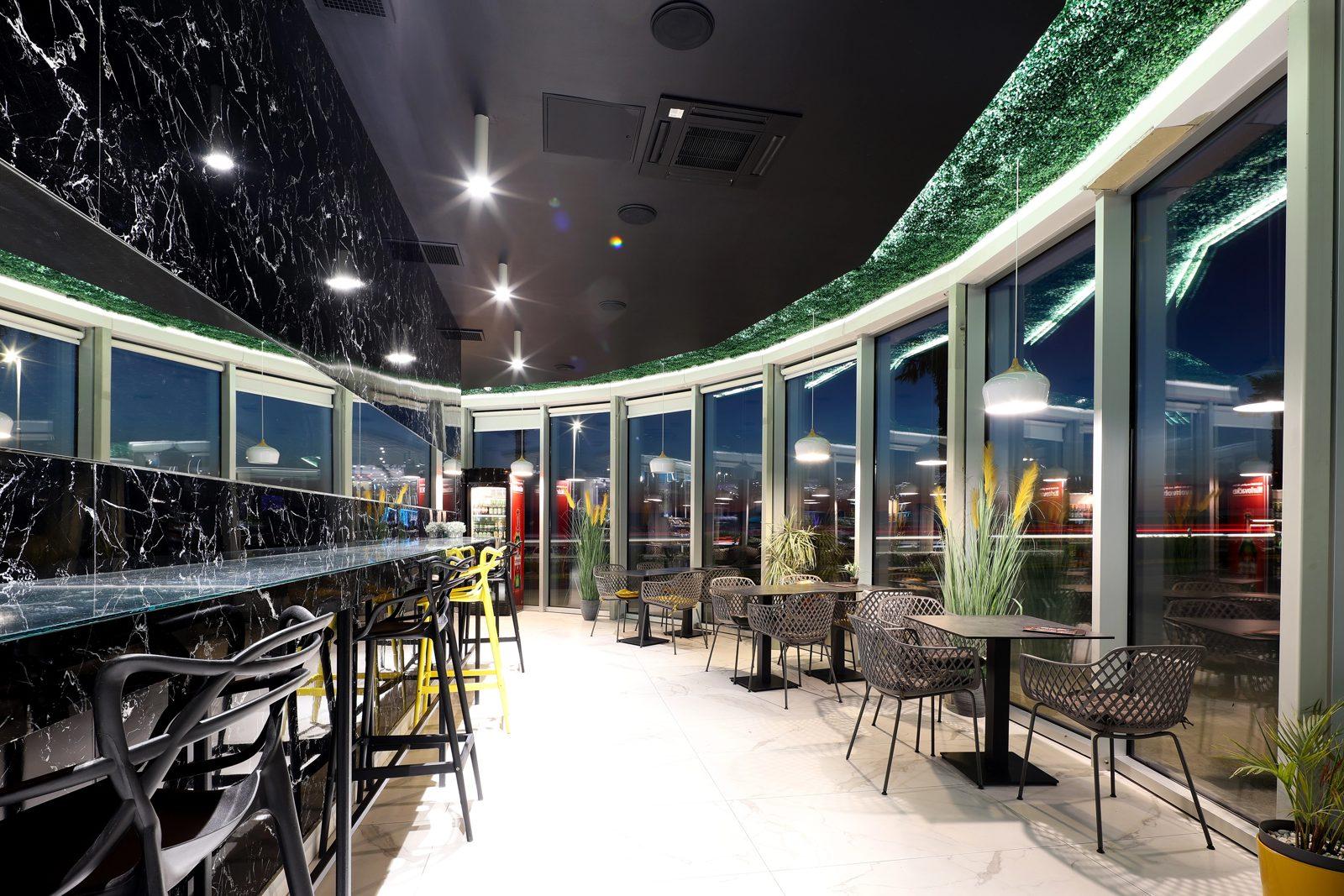 Interior of the Meet Caffe at night with marble bar and panoramic windows